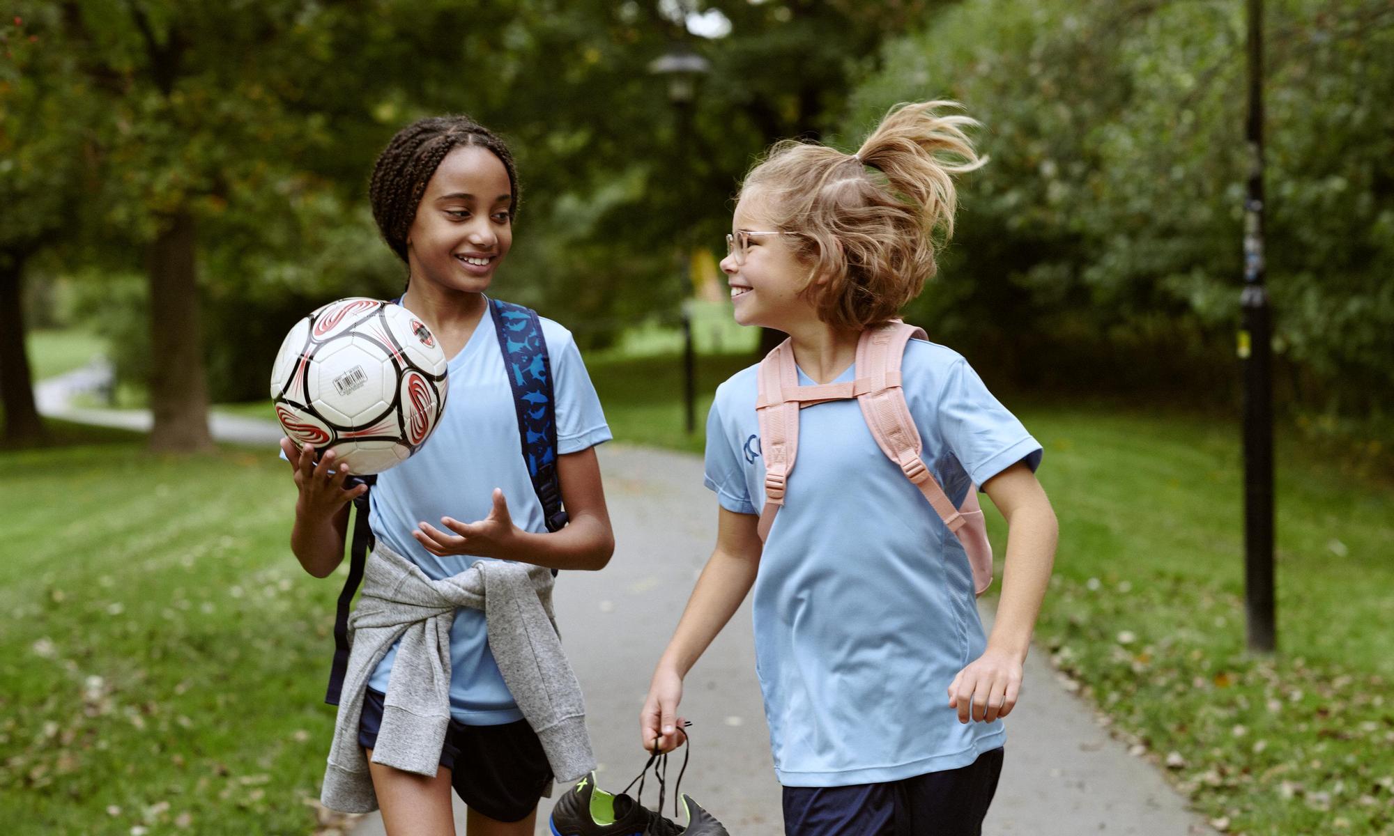 Two kids walking to soccer practice 