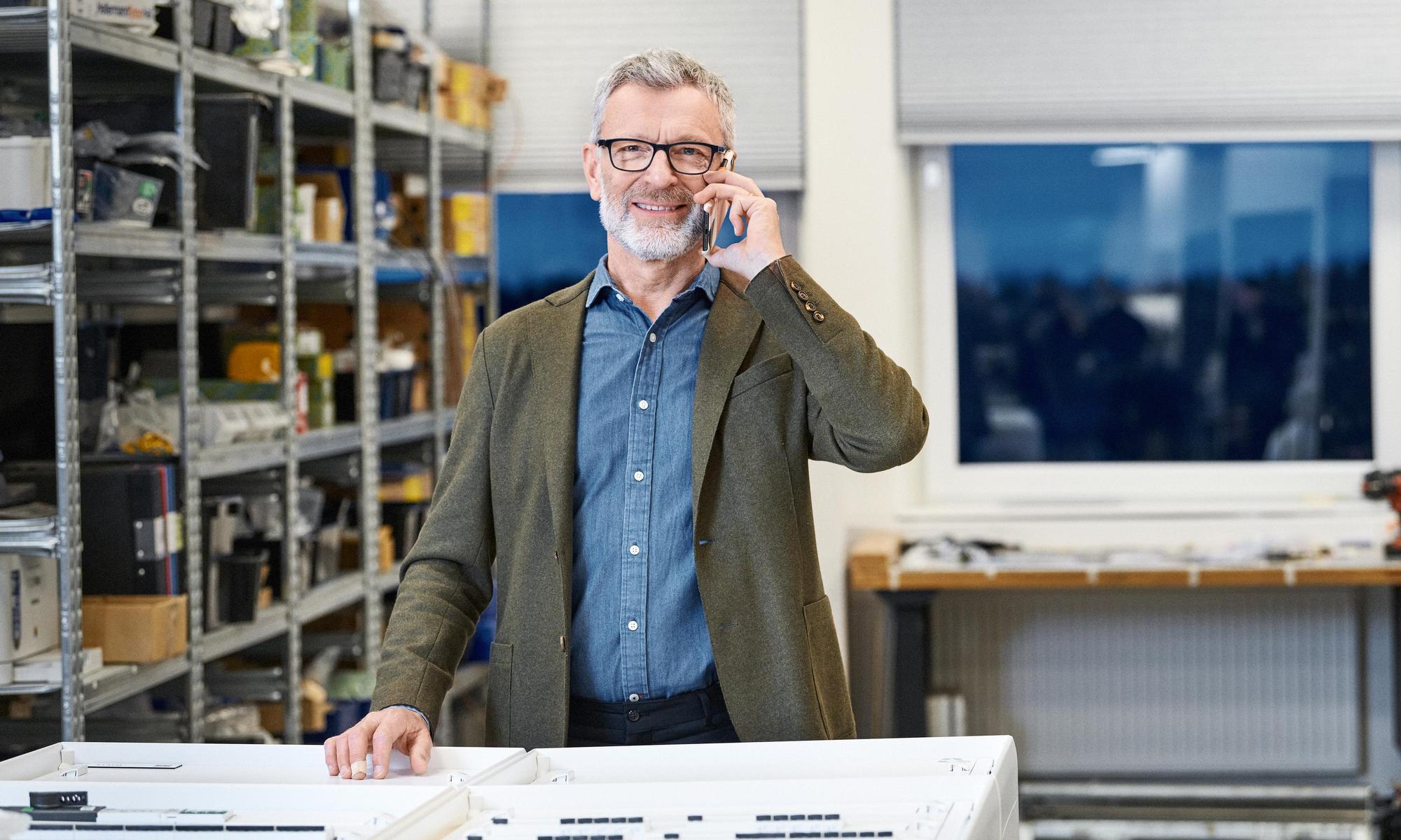 Man standing at a company talking in his mobile