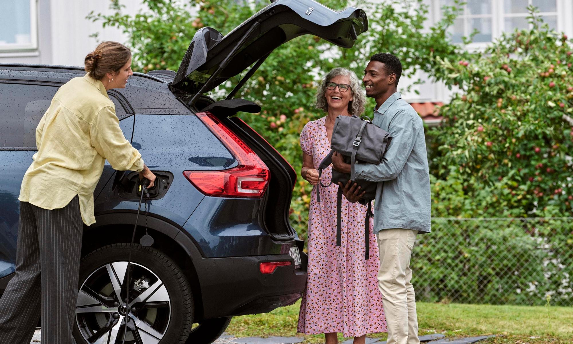 Group of people talking while they wait for the electric car to be fully charged