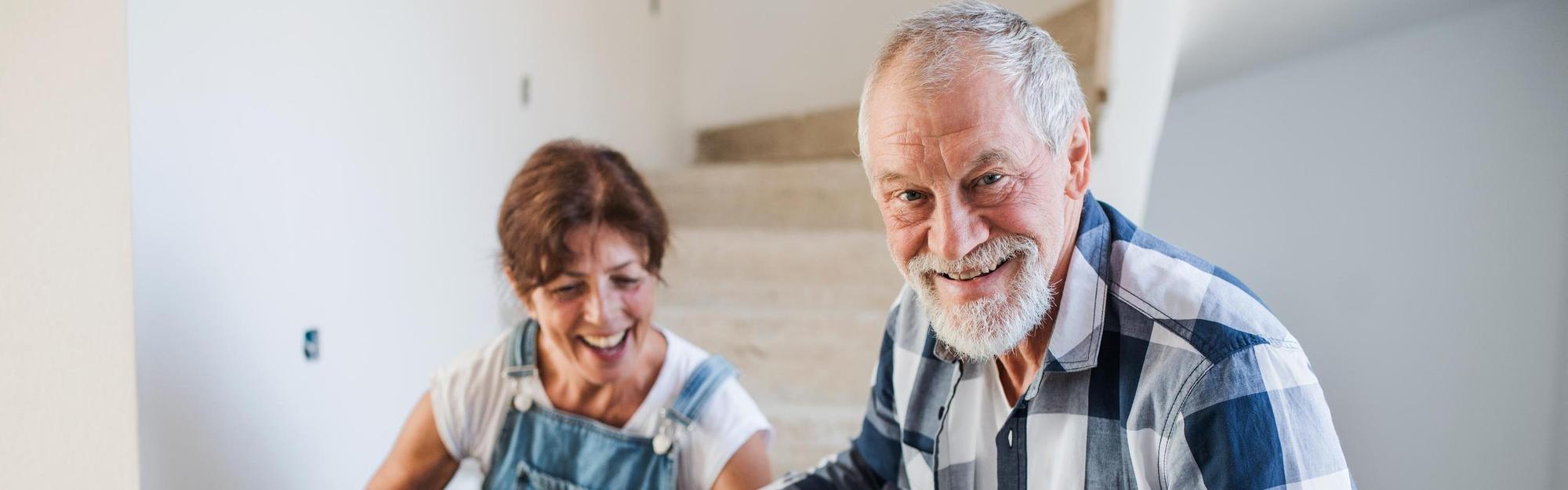 Old man and woman working on interior of new house or flat.