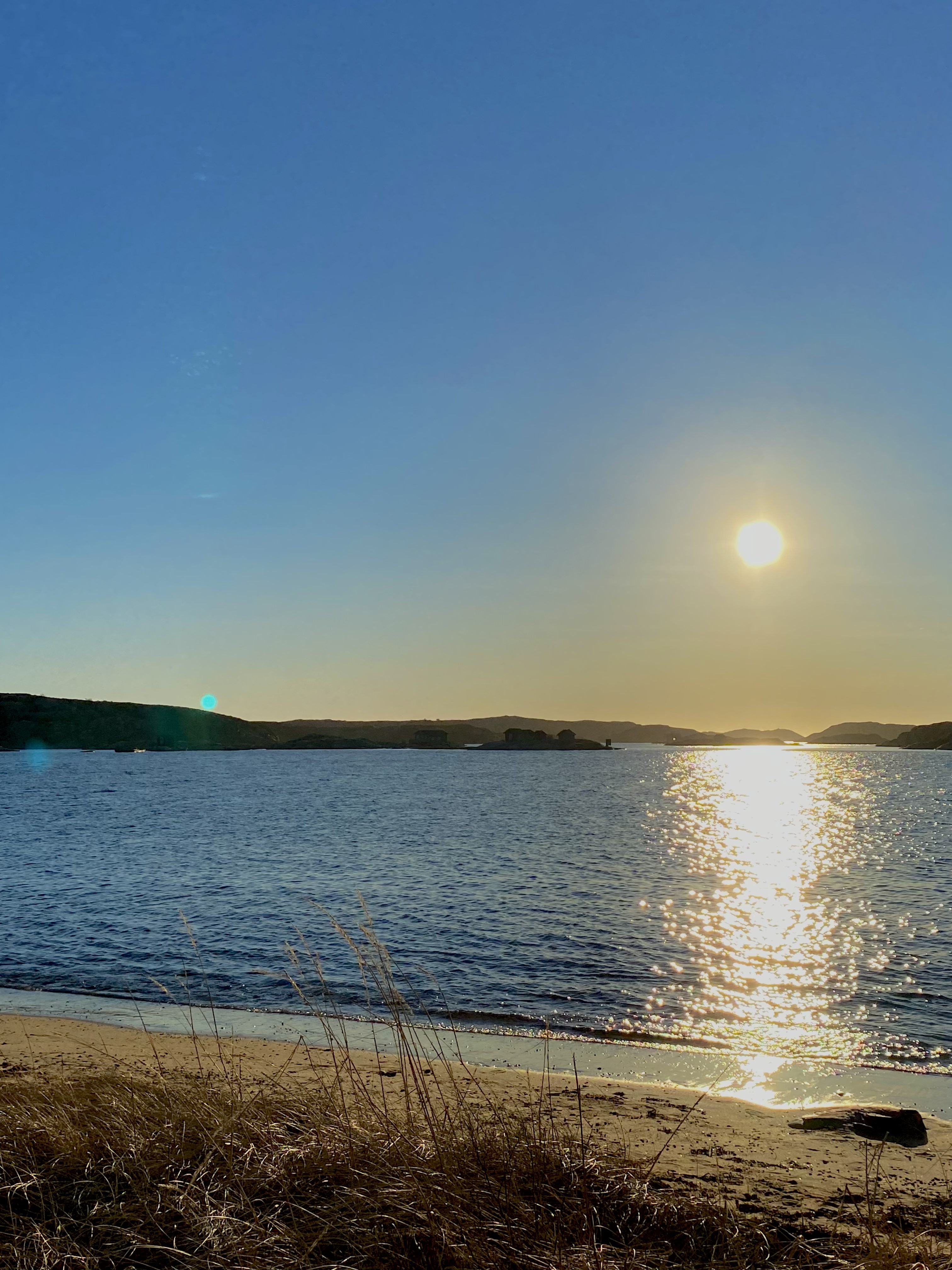 Solen går ner över havet vid en strand