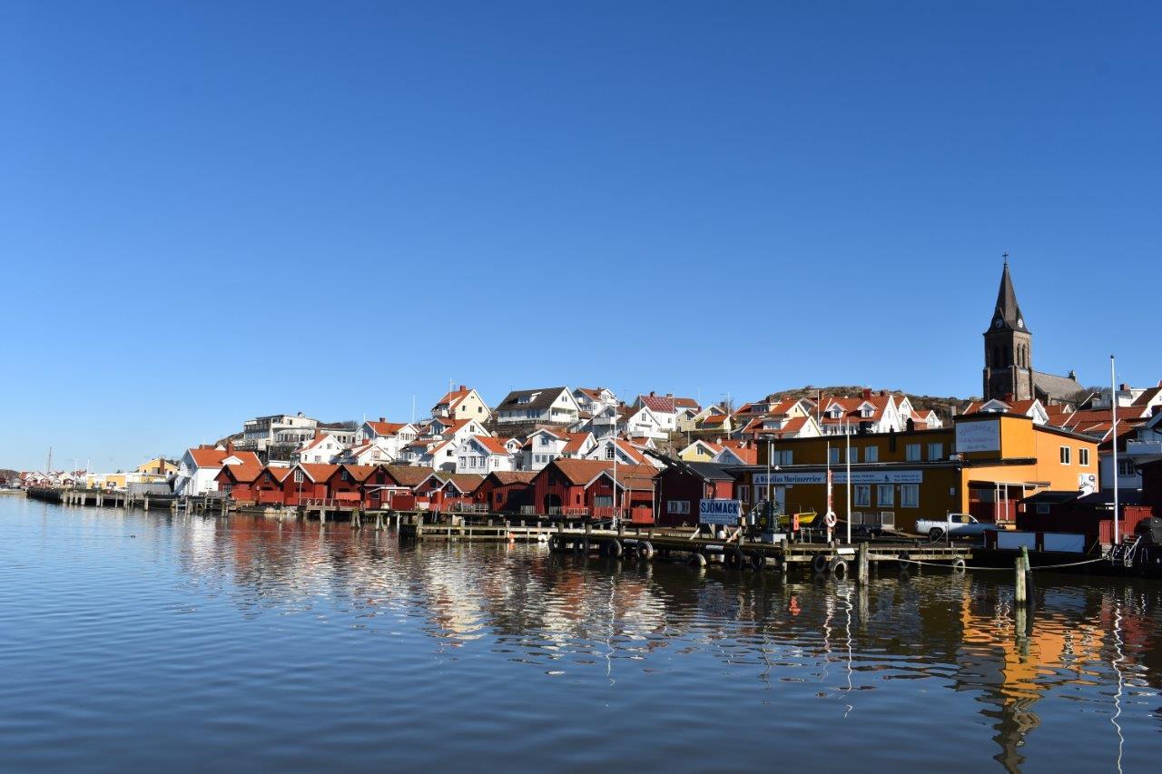 Hus, sjöbodar och kyrka i Fjällbacka sett från havet